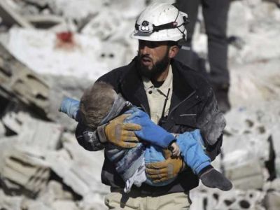 Волонтер "Белых касок" со спасенным ребенком. Фото: Reuters Волонтер "Белых касок" со спасенным ребенком. Фото: Reuters