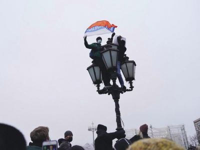 Два человека на фонаре во время митинга. Один с плакатом "Один за всех и все за одного", другой с флагом России и словом "Владивосток". Фото: Наталья Буданцева / ОВД-инфо" Два человека на фонаре во время митинга. Один с плакатом "Один за всех и все за одного", другой с флагом России и словом "Владивосток". Фото: Наталья Буданцева / ОВД-инфо"