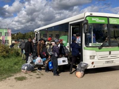 Группа рабочих мигрантов предприятия "Экоокна" садится в автобус, чтобы покинуть Бужаниново, где накануне прошел народны сход. Фото: "Би-би-си" Группа рабочих мигрантов предприятия "Экоокна" садится в автобус, чтобы покинуть Бужаниново, где накануне прошел народны сход. Фото: "Би-би-си"