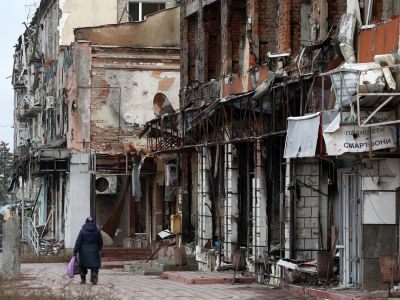 Местная жительница проходит мимо разрушенных зданий в Изюме Харьковской области, 25 ноября 2022 год. Фото: Анатолий Степанов/AFP/Getty Images Местная жительница проходит мимо разрушенных зданий в Изюме Харьковской области, 25 ноября 2022 год. Фото: Анатолий Степанов/AFP/Getty Images