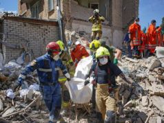 Спасатели несут тело погибшего при ракетном обстреле, Киев. Фото: ДСНС Киева / Reuters